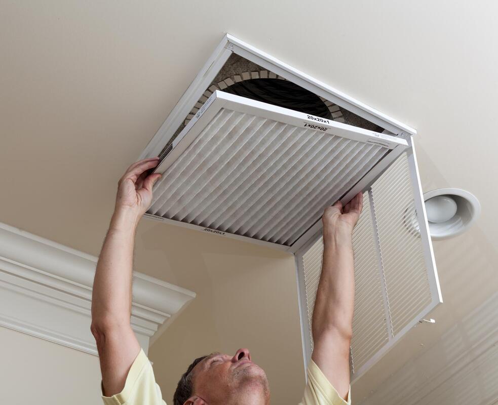 a man changing the filter of air vent